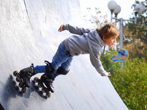 Active Young Boy Enjoying A Day Rollerblading Wallpaper