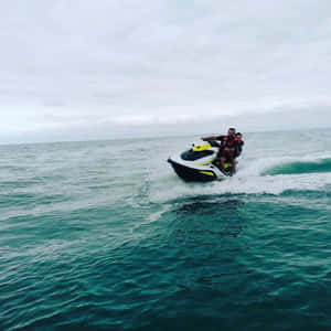Adventurous Couple Enjoying A Jet Ski Ride Wallpaper
