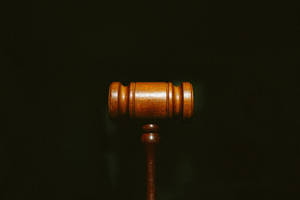 Advocate Wooden Gavel In Solid Black Wallpaper