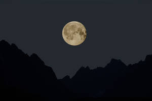 Aesthetic Silhouette Of A Full Moon On A Crisp Night Sky Wallpaper