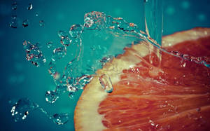 Aesthetic Sliced Grapefruit Water Splash Wallpaper