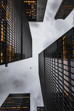 Airplane Flying Over Skyscrapers Wallpaper