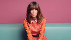 Alexa Chung Orange Lace Dress Pink Backdrop Wallpaper