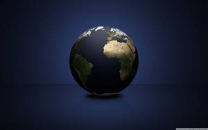 An Antique World Globe Stands Atop A Bookshelf. Wallpaper