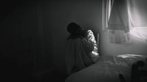 An Individual Contemplating In Solitude Amidst A Serene Backdrop Wallpaper