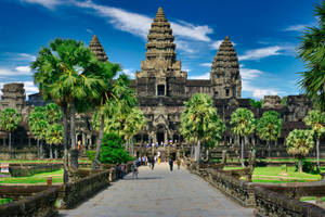 Angkor Wat Surrounded By Nature Beneath Blue Sky Wallpaper