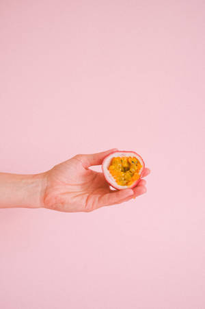 Anonymous Hand Showing Sliced Passion Fruit Wallpaper