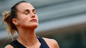 Aryna Sabalenka In Her Zen Moment On Court Wallpaper