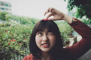 Asian Woman Playing With A Flower Wallpaper