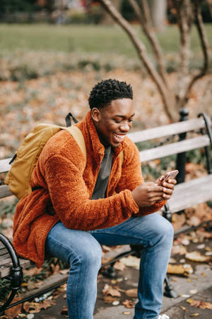 Autumn Phone Man In Orange Jacket Wallpaper