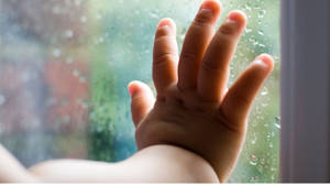 Baby Hand Leaning On Glass Panel Wallpaper