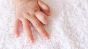 Baby Hand Touching A Soft Fabric Wallpaper