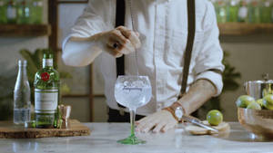 Bartender Mixing Tanqueray Gin With Tonic Wallpaper