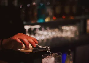 Bartender Pouring Drinkat Bar Wallpaper