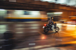 Bike Rider Riding Through An Illuminated Road Wallpaper