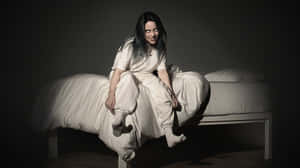 Billie Eilish Typing Away On Her Laptop Wallpaper