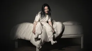 Billie Eilish Typing Away On Her Laptop Wallpaper