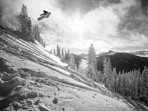 Black And White Man With Snowboard Down Slope Wallpaper