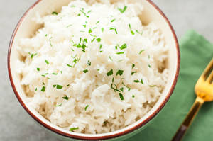 Bowl Of White Rice With An Herb Garnish Wallpaper