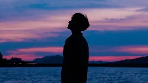 Boy Silhouette In Purple Sky Wallpaper