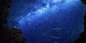 Breathtaking Meteor Shower In The Night Sky Wallpaper