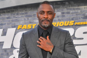 British Actor Idris Elba Stylishly Adjusting His Tie Wallpaper