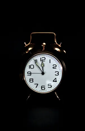 Bronze Clock On Black Backdrop Wallpaper