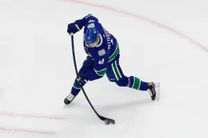 Canadian Nhl Player Elias Pettersson In Blue Jersey Wallpaper