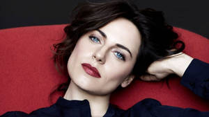 Caption: Antje Traue In Chic Red Chair Wallpaper