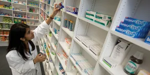 Caption: Dedicated Female Pharmacist Engaged In Medicine Check Wallpaper