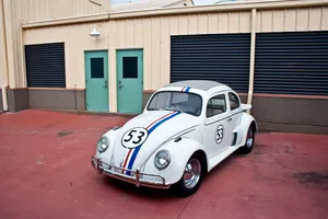Caption: Herbie The Love Bug Parked By A Building In The Movie