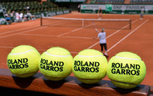 Caption: Iconic Clay Courts - A Close-up View Of Tennis Balls At The French Open Wallpaper