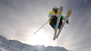 Caption: Intense Action Mid-air - Ski Jumper In Motion Wallpaper