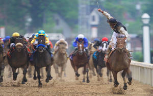 Caption: Intense Horse Racing On A Muddy Track Wallpaper