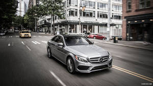 Caption: Luxurious And Sleek Mercedes Benz C300 On The Road Wallpaper