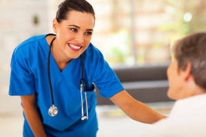 Caption: Polite Nurse Administering Treatment To A Patient Wallpaper