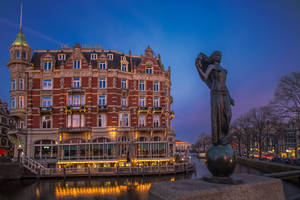 Caption: Quaint Restaurant Flore Amidst Dutch Cityscape Wallpaper