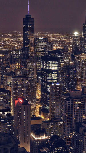 Caption: Sky View Of A City Glowing At Night Wallpaper