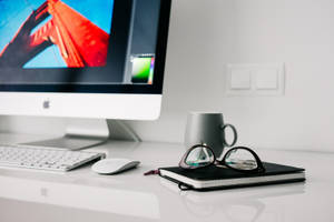 Caption: Sophisticated Mac Workspace Setup On A Clean Wooden Desk Wallpaper