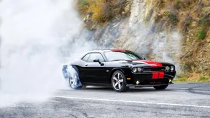 Caption: Stunning Dodge Challenger Showcasing Red Racing Stripes On A Picturesque Sunset Backdrop. Wallpaper