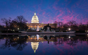 Caption: The United States Capitol Under A Stunning Starry Night Sky Wallpaper