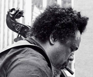 Charles Mingus Smoking While Carrying Bass Guitar Wallpaper