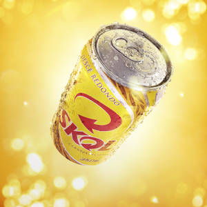 Chilled Skol Beer Can In A Vibrant Yellow Background Wallpaper