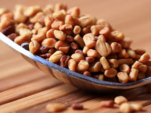 Close Up Of A Spoon With Fenugreek Seeds Wallpaper