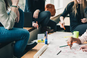 College Students Engaged In A Group Study Session Wallpaper