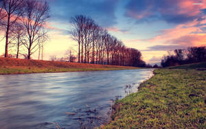 Colorful Skies Over The Riverside Wallpaper