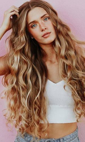 Confident Blonde Woman Flaunting Her Gorgeous Curly Hair Wallpaper