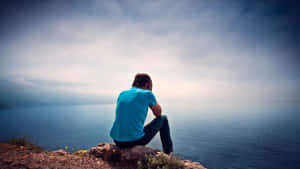 Cool Sad Boy Wearing Blue Shirt Wallpaper