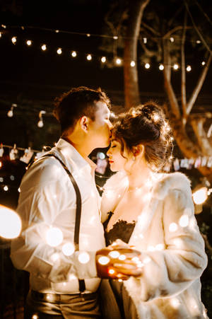 Couple Dancing Under Twinkle Lights Wallpaper