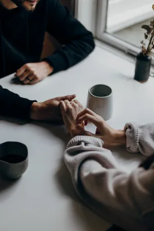 Couple Holding Hands On Table Wallpaper